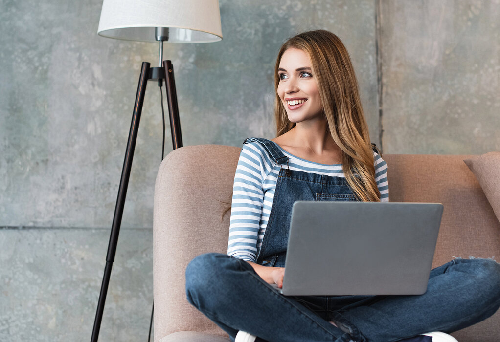 Frau mit Laptop auf dem Sofa