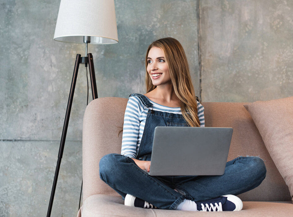 Frau mit Laptop auf dem Sofa